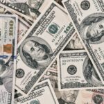A scattered pile of American one hundred dollar banknotes